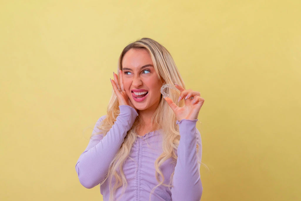 Persona con alineadores invisibles en la mano